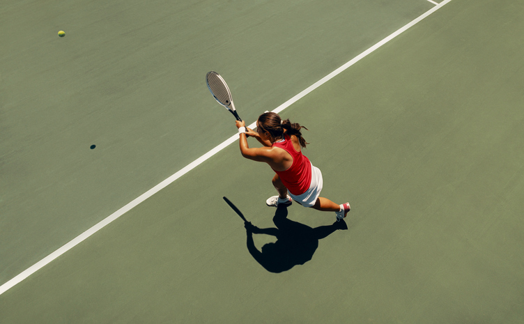 Vrouw speelt tennis op de tennisbaan